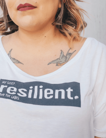 A woman wearing a shirt with a body positivity message on it